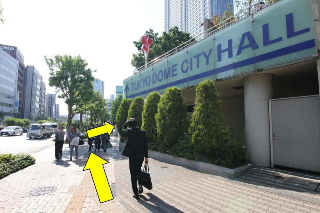 右手に「TOKYO DOME CITY HALL」の看板が見えてきたら、そのすぐ先を右に曲がります
